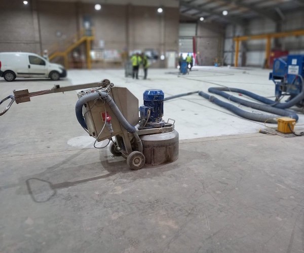 Diamond Floor Grinding a large warehouse floor to remove laitance in preparation for painting